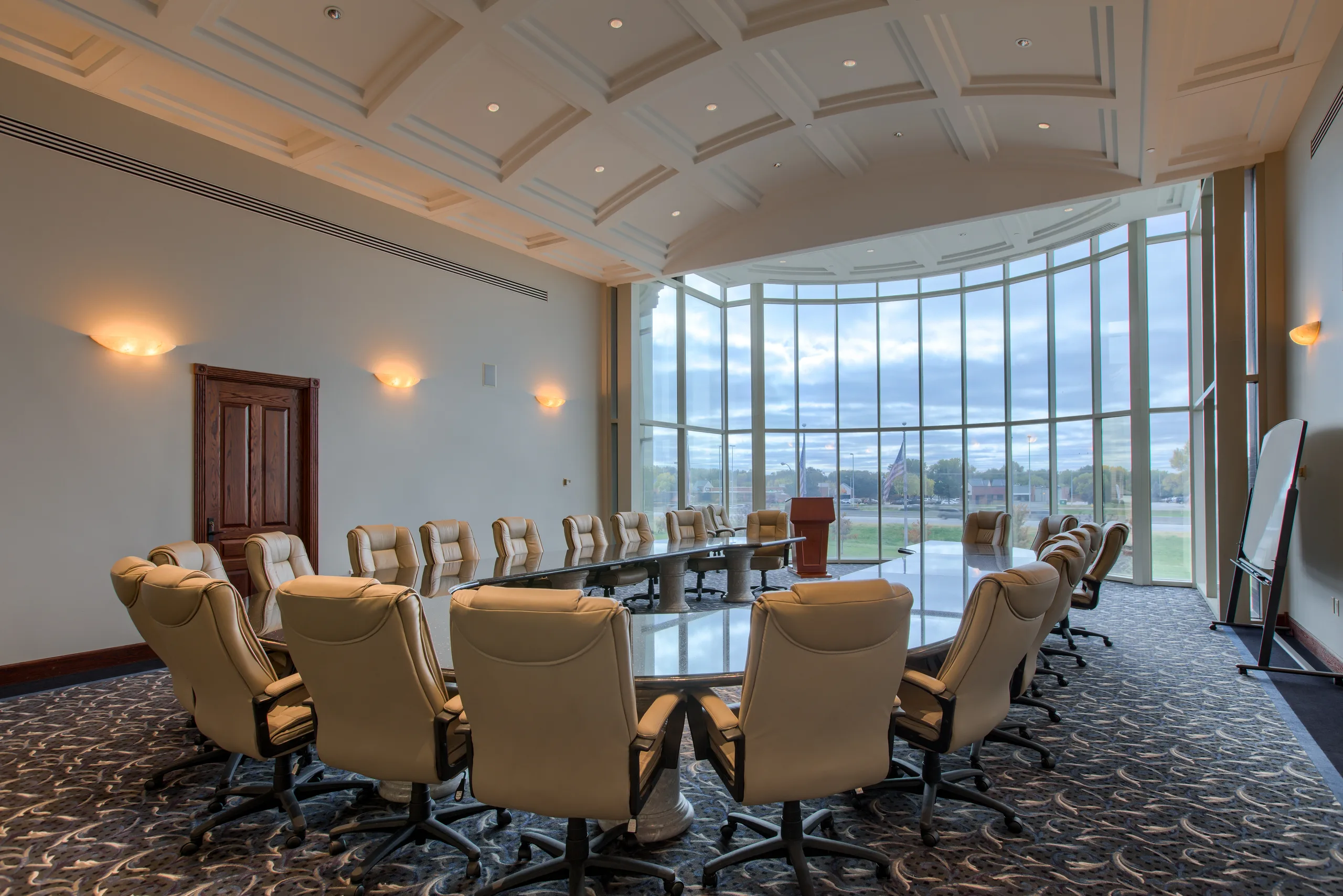 Executive board room with curved seating arrangement, suitable for up to forty people.