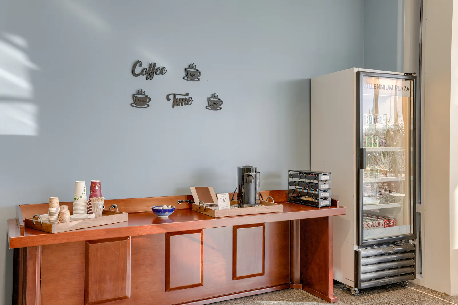 Tenant coffee station with marble counter and stone backsplash.