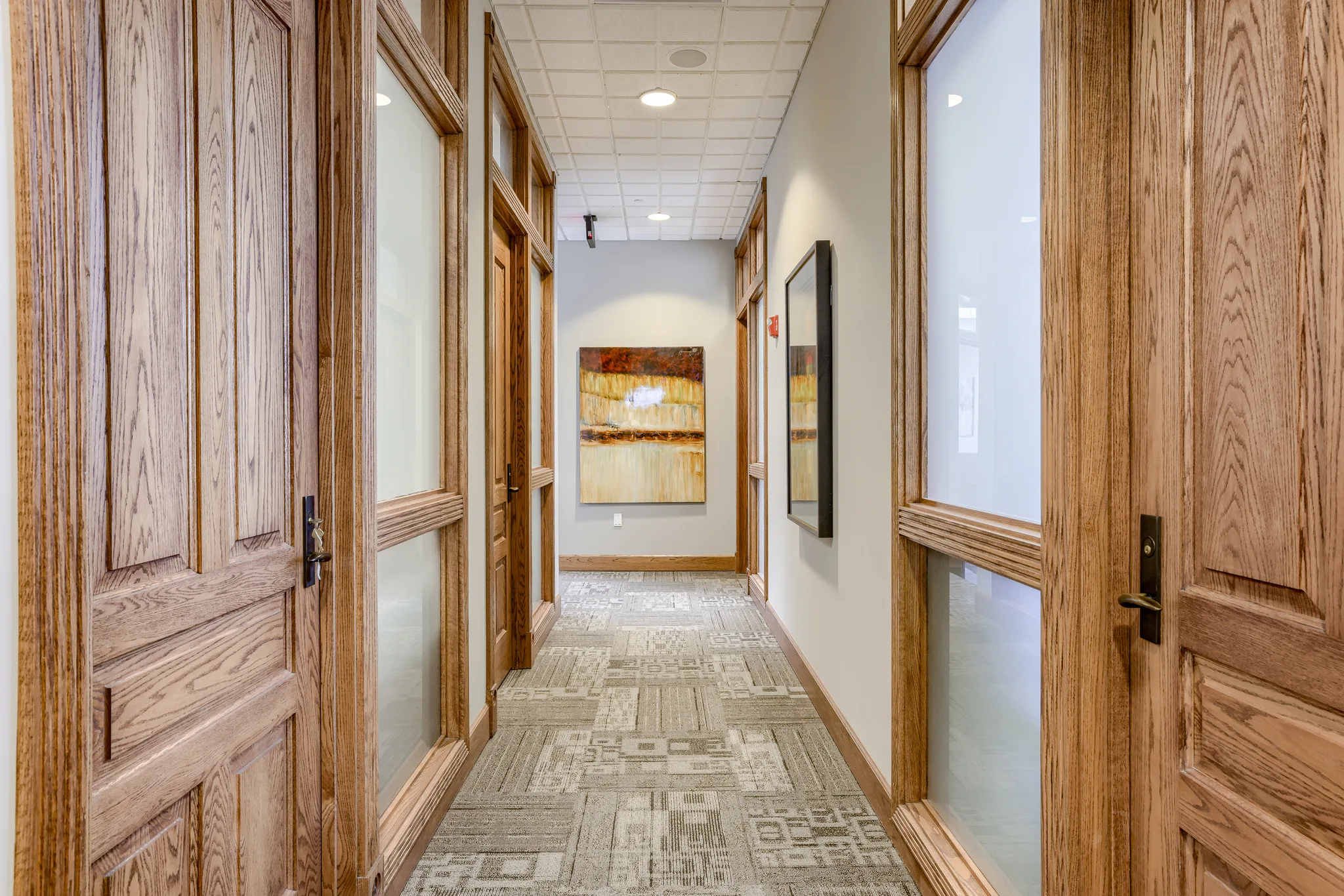 A wood-paneled corridor between tenant suites at Millennium Plaza.
