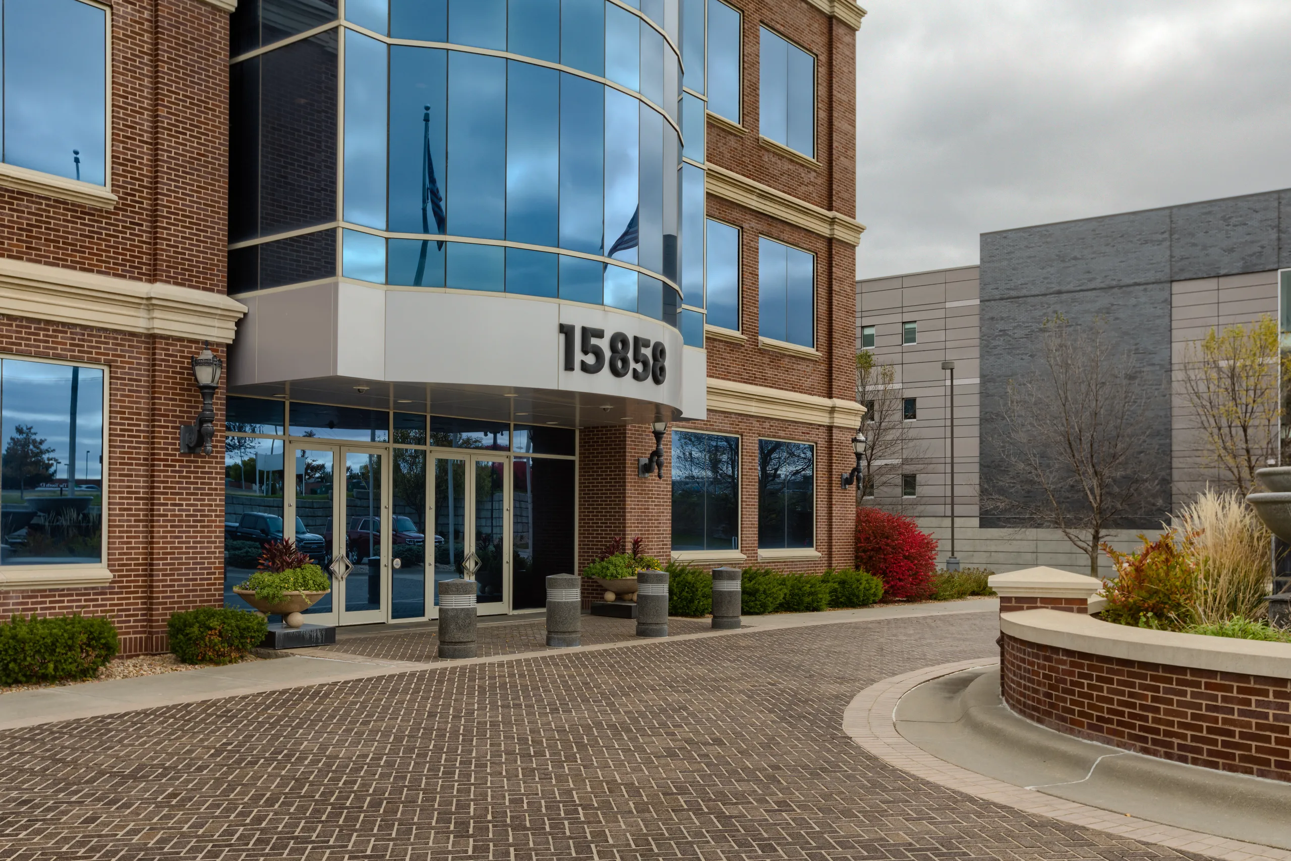 The exterior entrance at 15858 W. Dodge Road, signaling the main lobby doors.