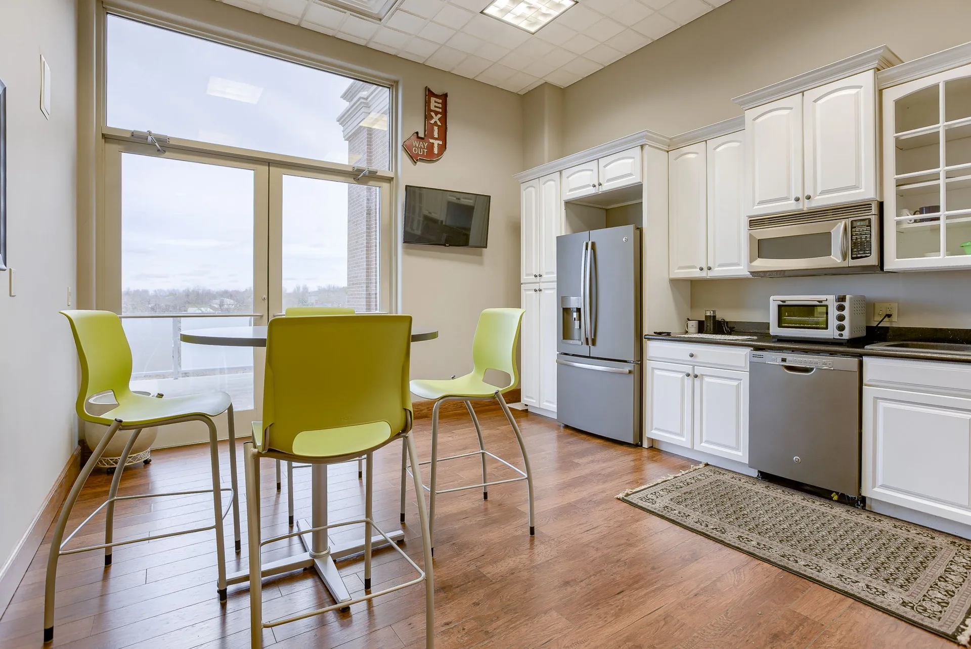 In-suite kitchen with cabinetry and seating for tenant staff.